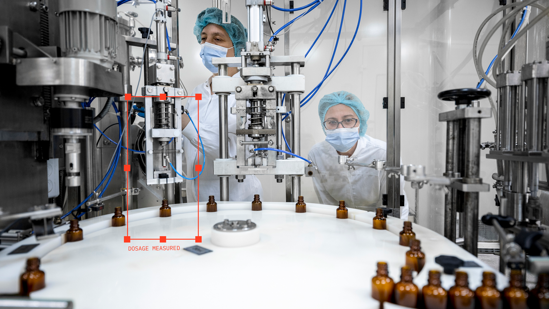 Technicians watching a vial filling machine